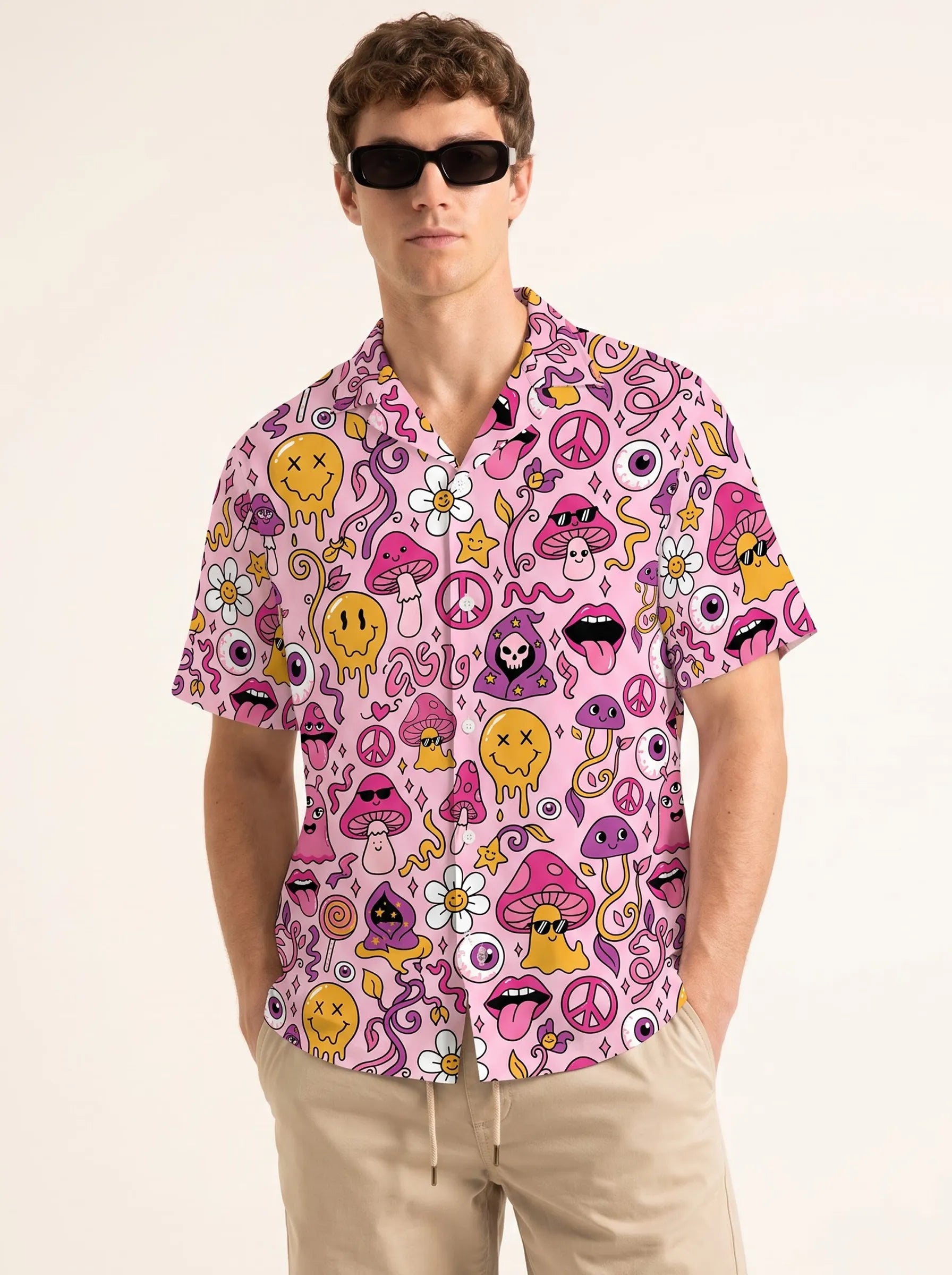 Male model wearing a pink trippy men's rave button up shirt with sunglasses and khaki shorts for a summer festival outfit