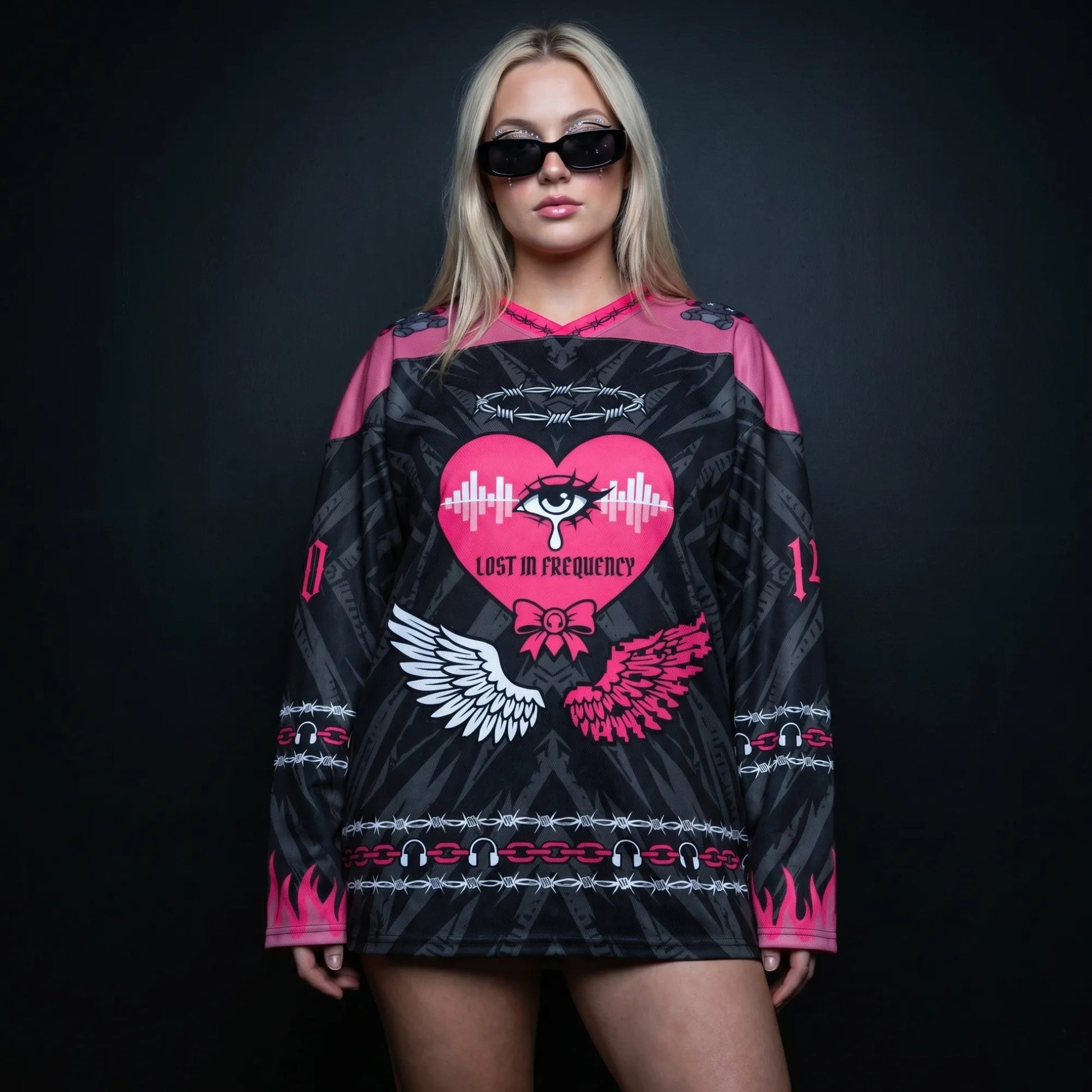 Female model wearing the oversized Pink Rave Hockey Jersey Recycled EDM Outfit, showcasing the relaxed festival fit, V-neck collar, and the striking cyber-gothic front graphics