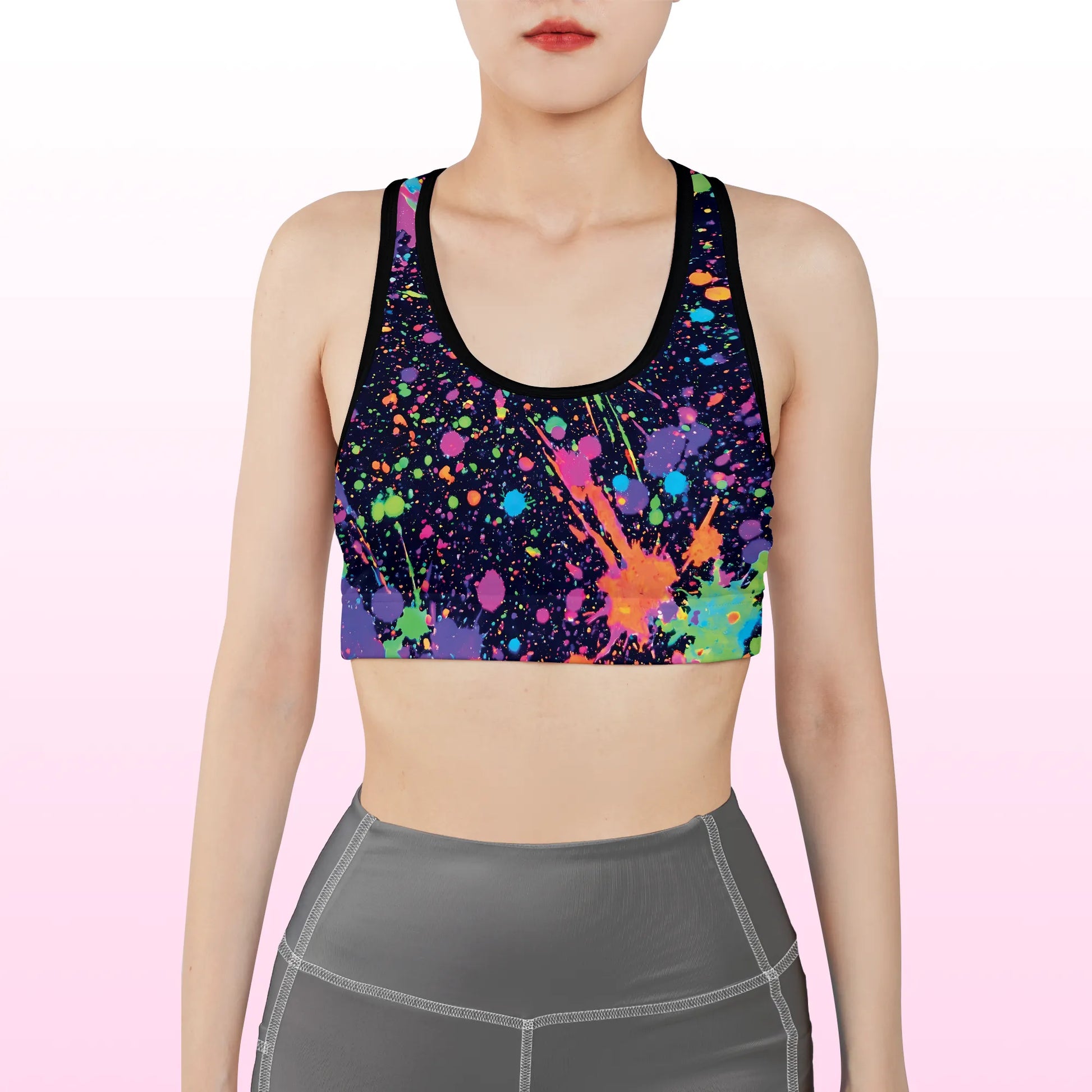 Front view of a woman wearing a black neon splatter spandex festival racerback rave bra