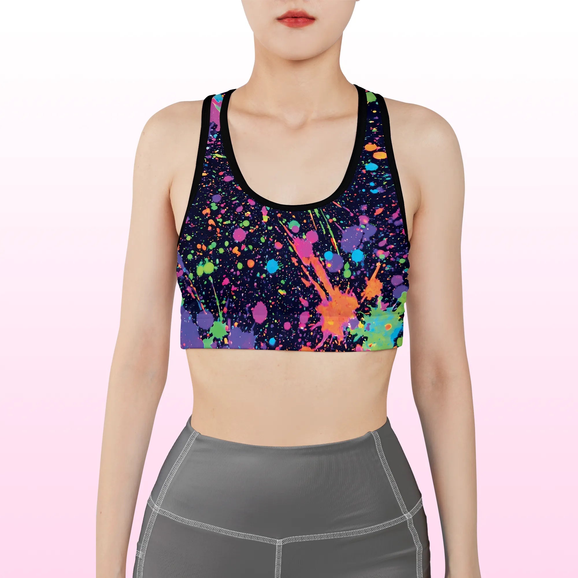Front view of a woman wearing a black neon splatter spandex festival racerback rave bra