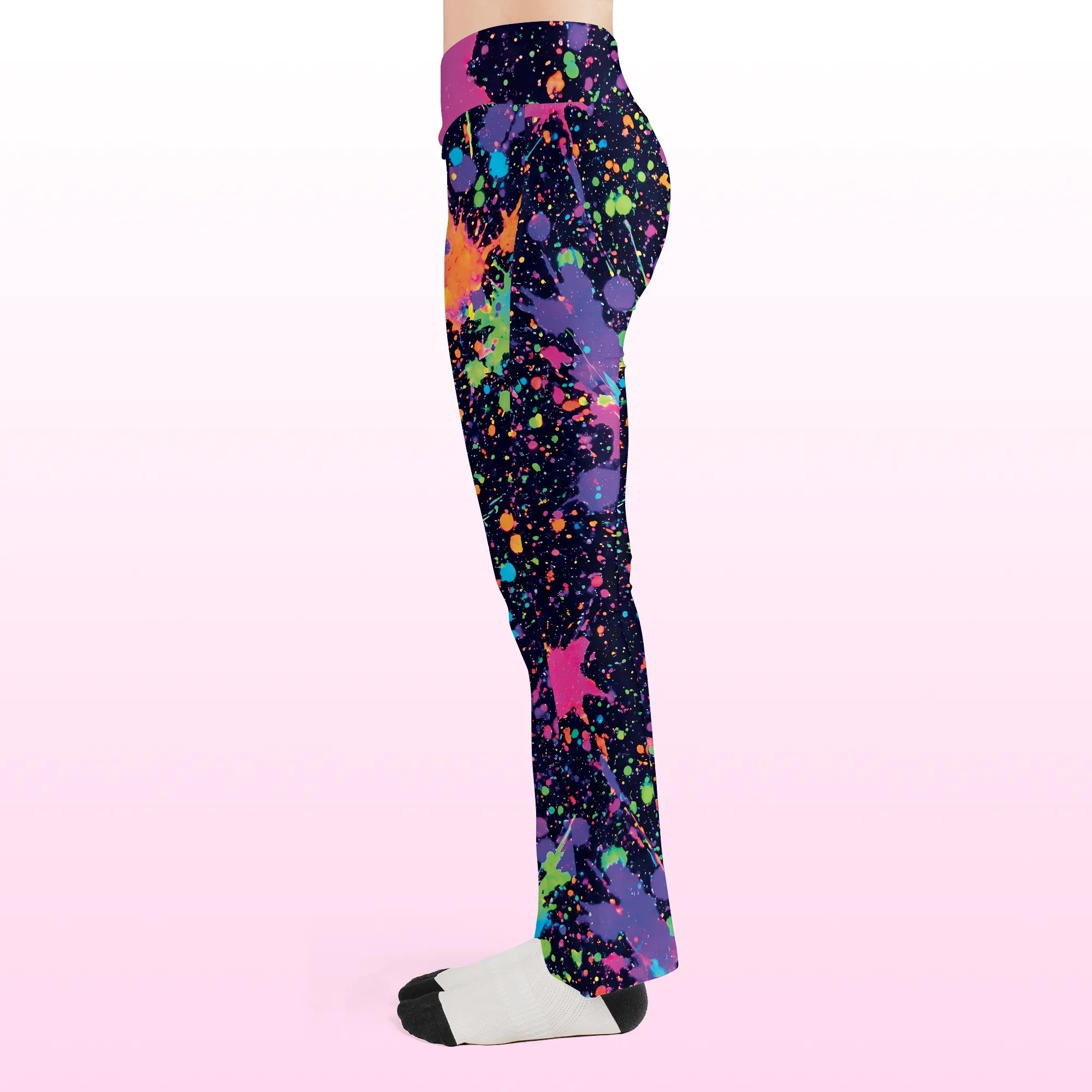 Left side view of the Neon Paint Splatter Flare Festival Pants, displaying the bold, colorful paint splatter pattern and comfortable flared fit for events