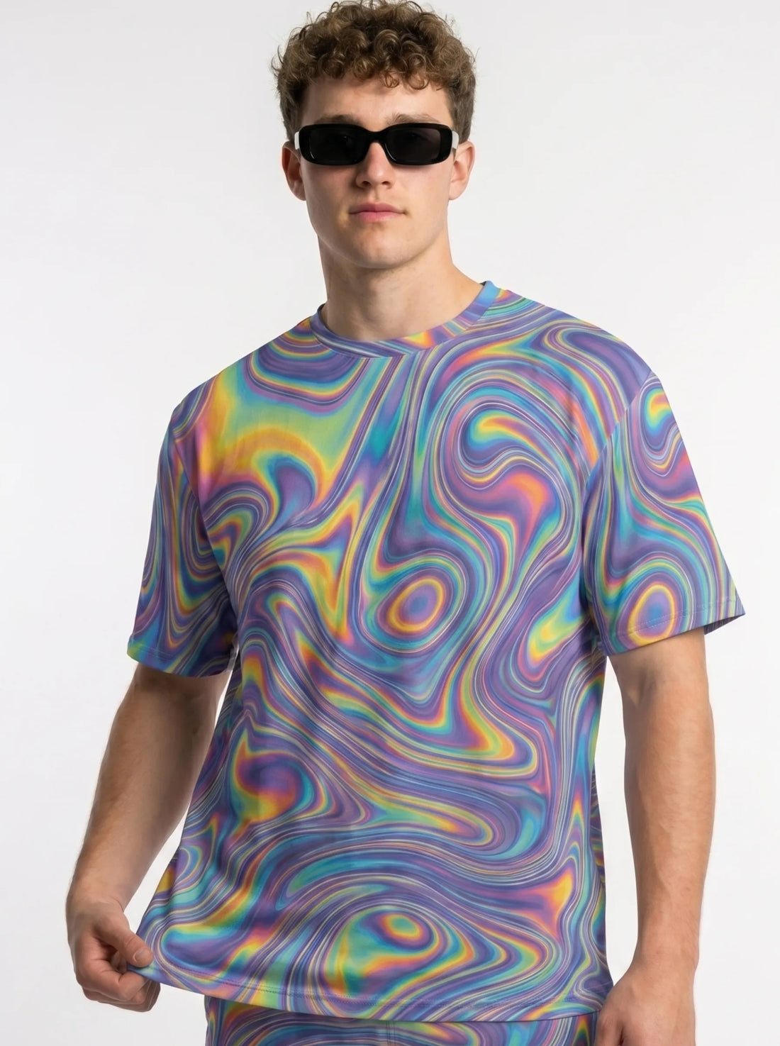 Front lifestyle view of a male model wearing the T Shirt Rave Mens Trippy Hologram Festival Top, featuring a vibrant psychedelic liquid swirl pattern