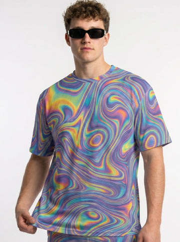 Front lifestyle view of a male model wearing the T Shirt Rave Mens Trippy Hologram Festival Top, featuring a vibrant psychedelic liquid swirl pattern
