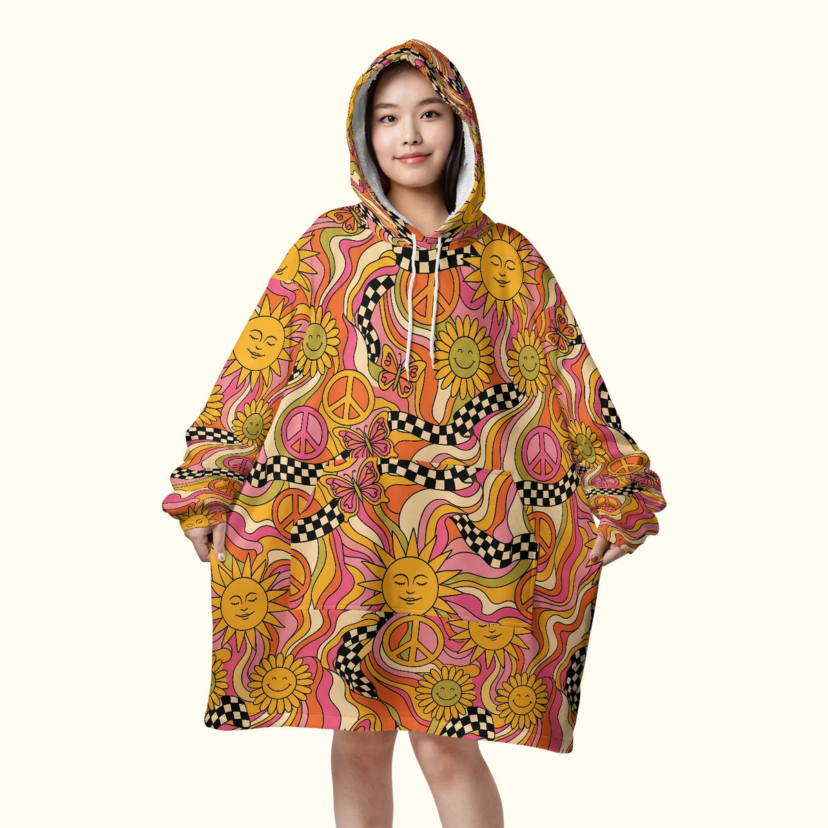 Front view of a woman wearing an oversized trippy blanket hoodie featuring pink and orange retro suns, perfect for cozy rave hippie outfits