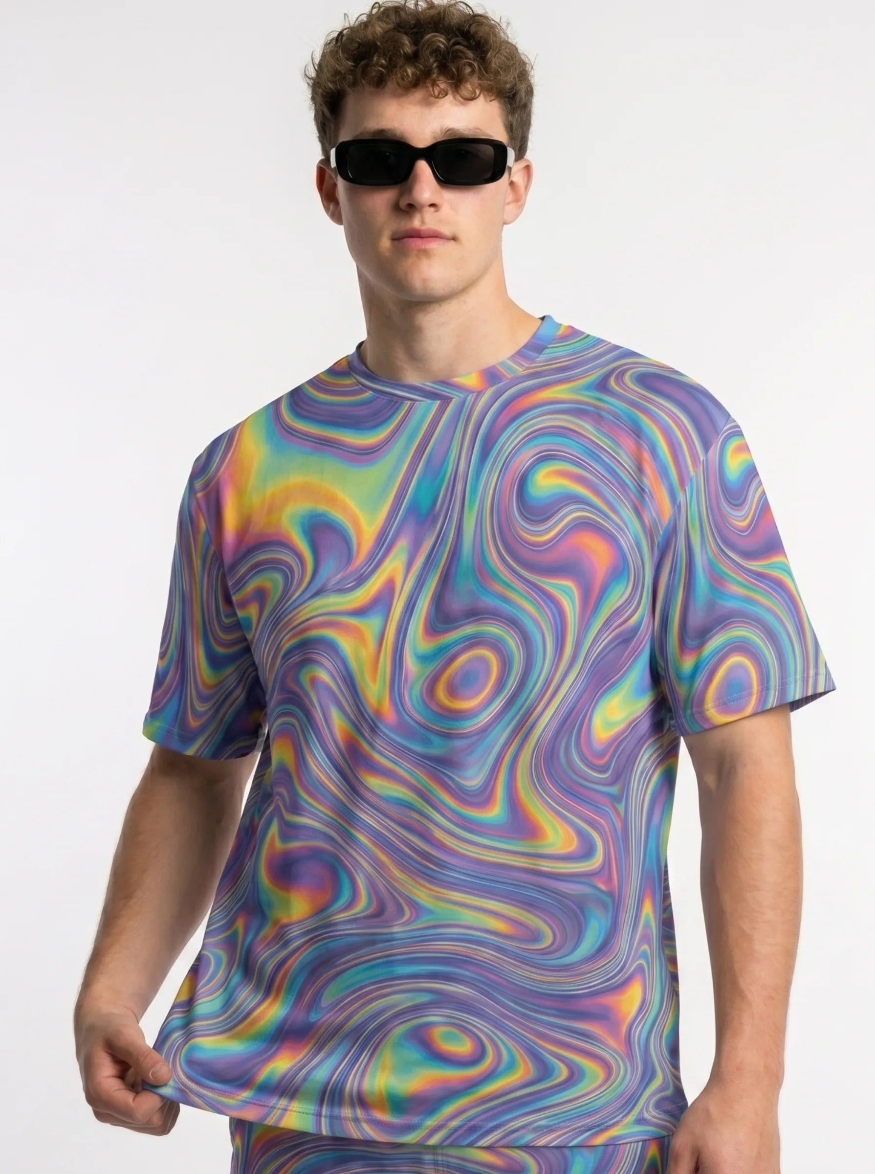 Male model wearing a matching psychedelic festival outfit featuring trippy mesh rave shorts and a coordinated t-shirt
