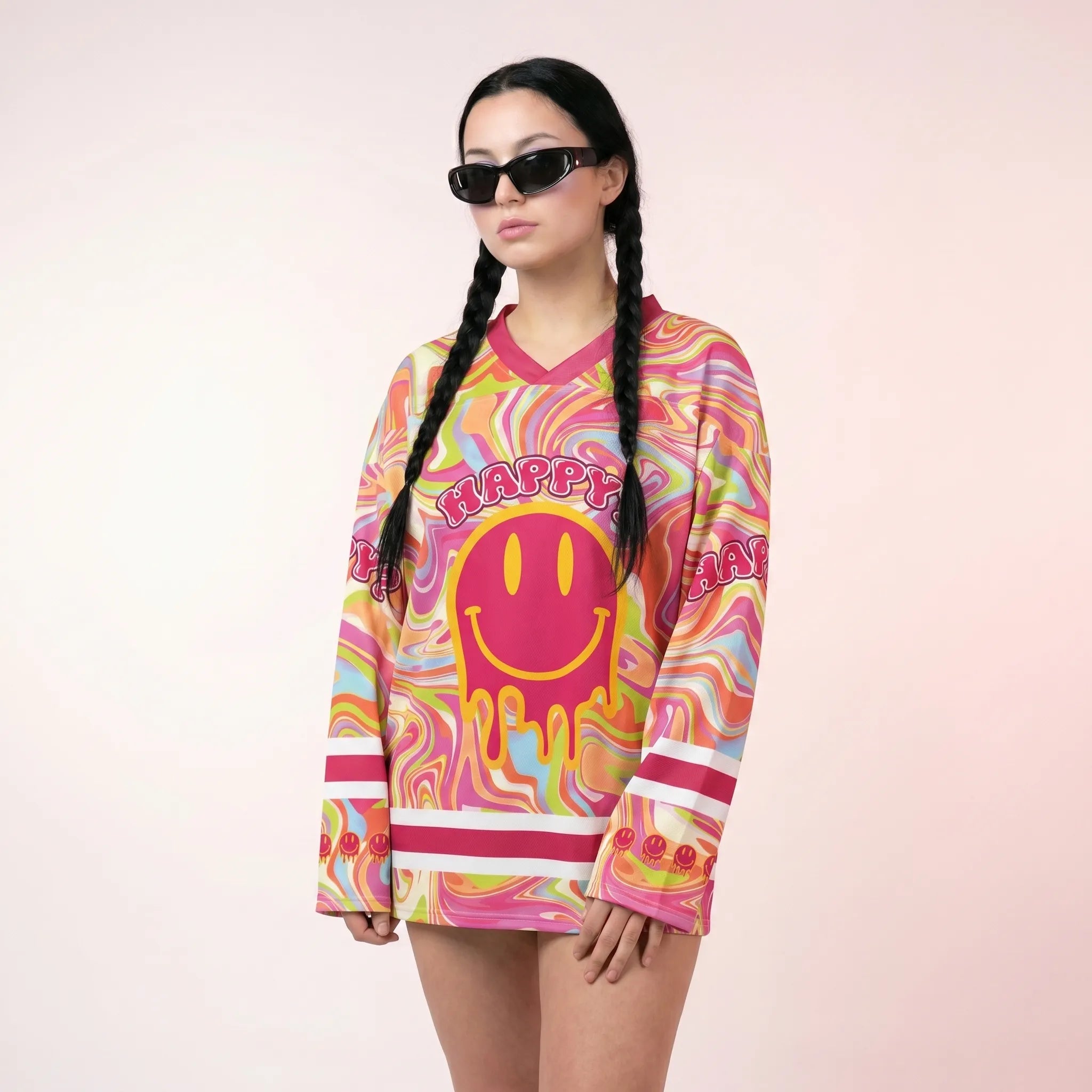 A woman wearing the trippy pink rave hockey jersey, featuring a vibrant psychedelic marble pattern and a large melting smiley face with the word "HAPPY?". A relaxed and breathable EDM festival outfit.